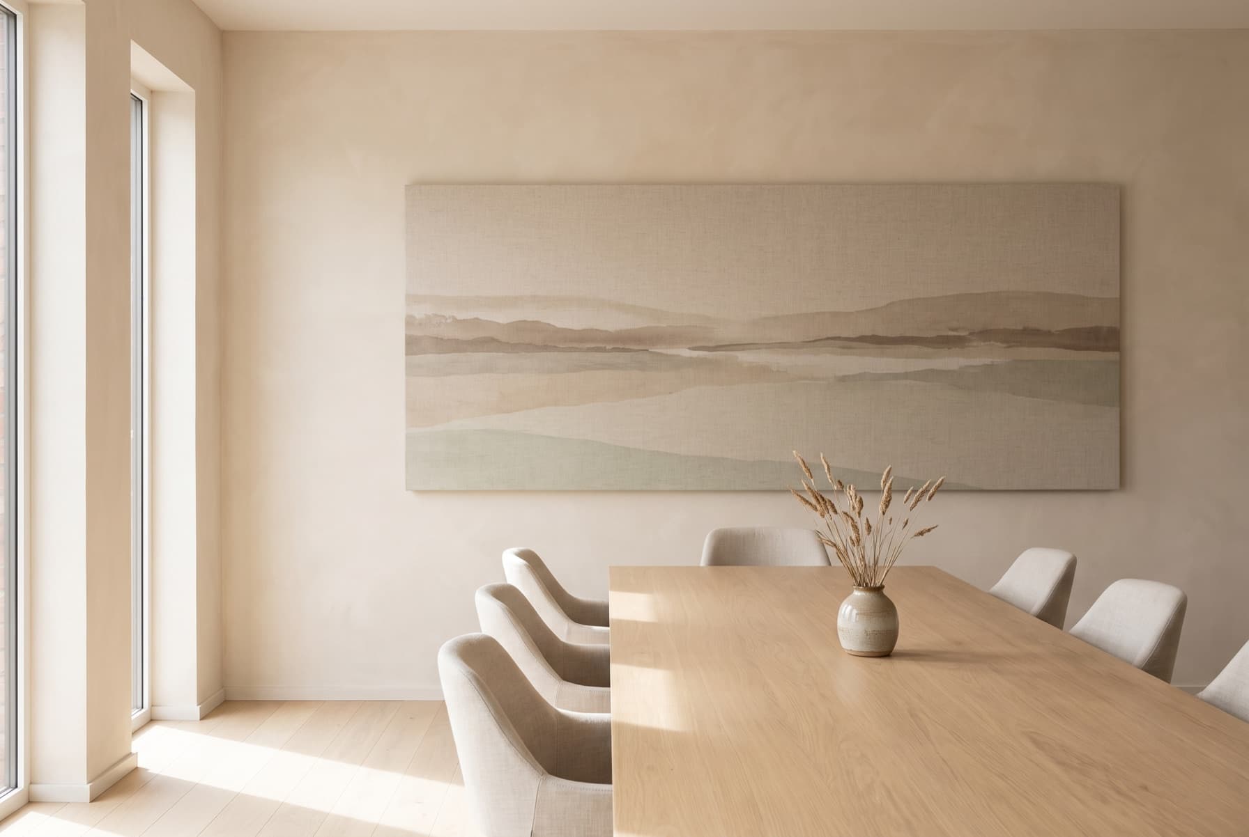 Comedor con mesa de roble y un panel panorámico de paisaje en tonos suaves ocupando la pared.