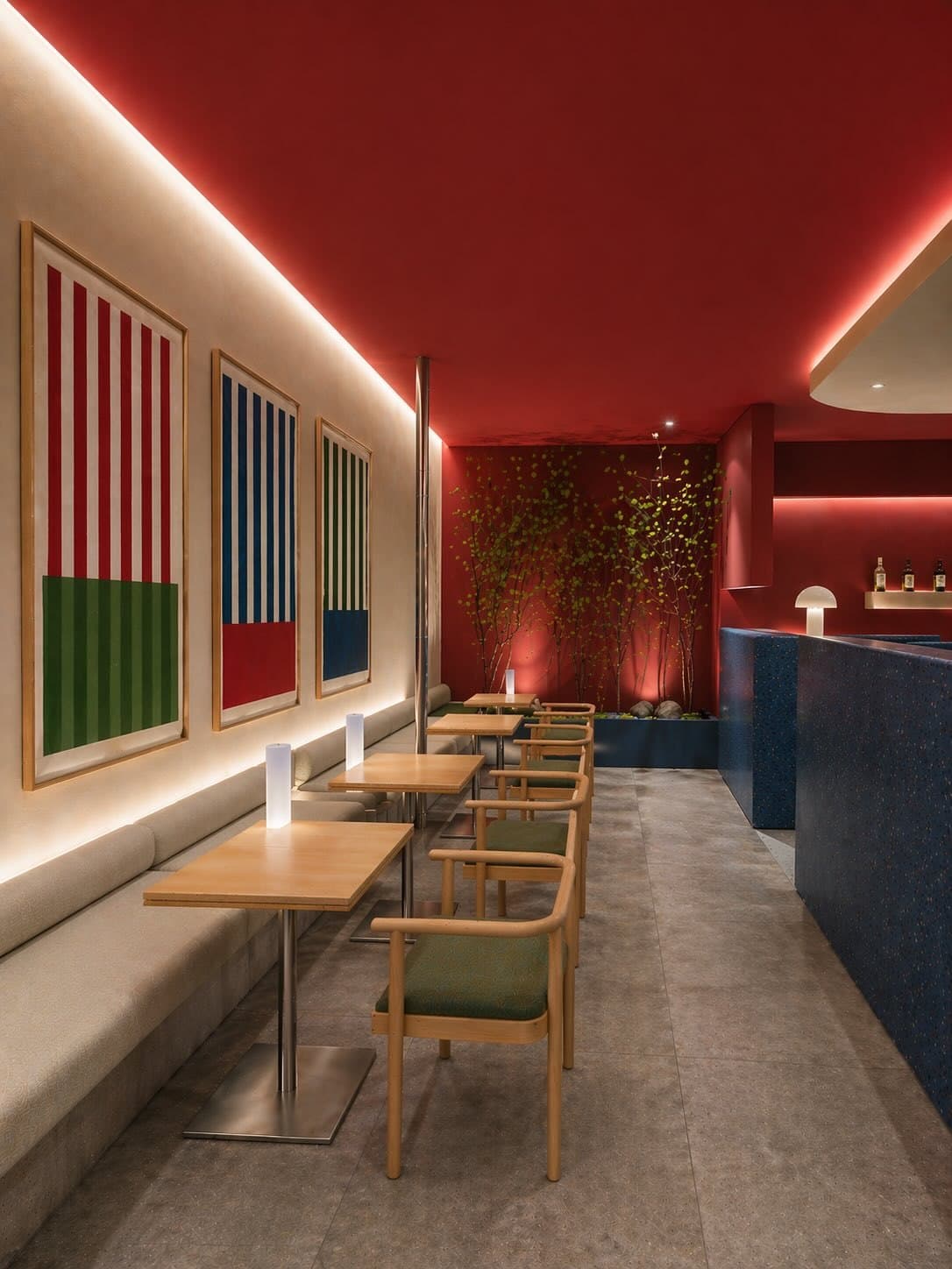 Restaurante de techo rojo con tres piezas geométricas enmarcadas sobre el banco corrido.