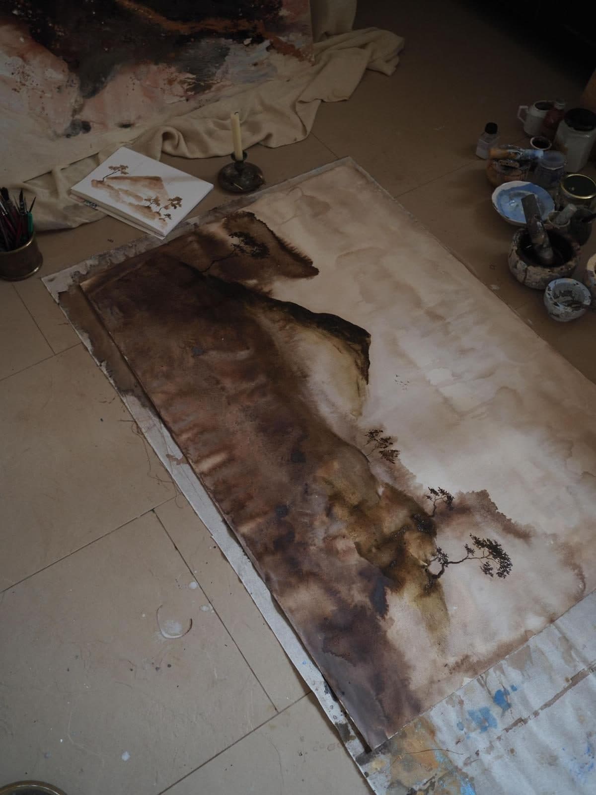 Obra de gran formato de Carla Kasseroler en proceso, extendida en el suelo del taller entre botes de pigmento.