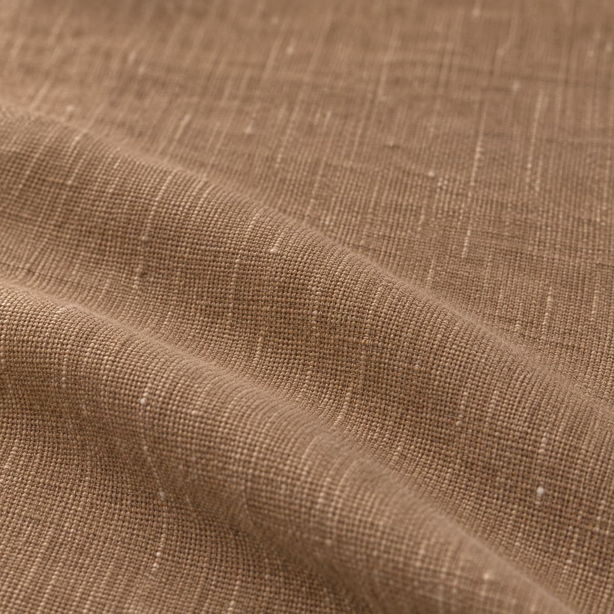 Macro de tela de algodón y lino en marrón tabaco, referencia 45, con vetas verticales suaves de hilo irregular, pliegue suave y luz rasante.