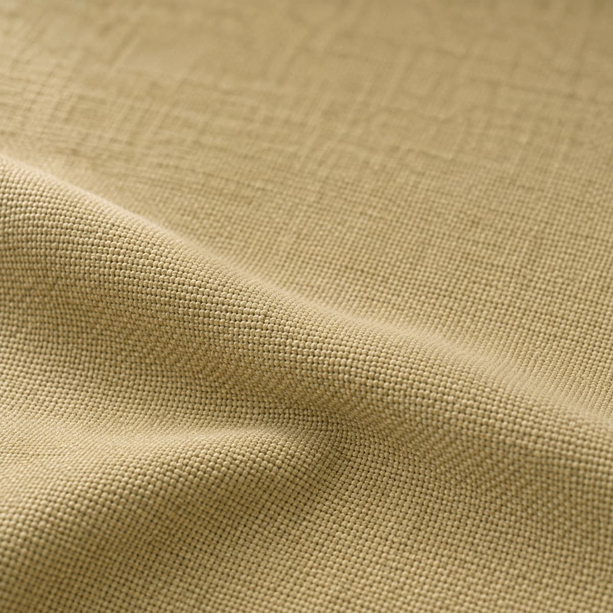 Macro de tela de algodón en color taupe, un beige arena cálido de tafetán tupido y mate, con un pliegue suave y luz rasante que levanta cada hilo.